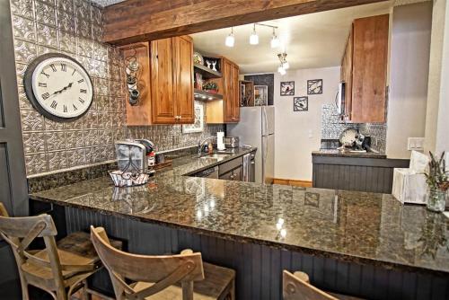 a kitchen with a counter and a clock on the wall at Deck with Views, Gas Grill, Renovated Luxurious Townhome on Burgess Creek in Steamboat Springs