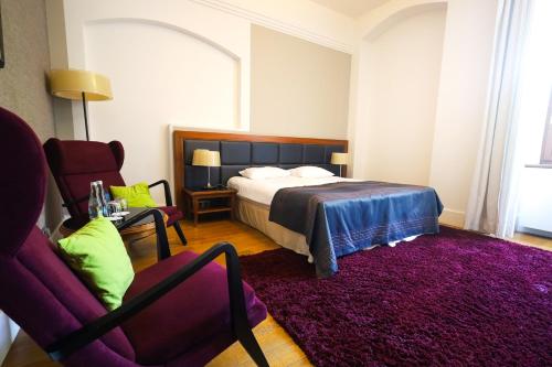 a bedroom with a bed and a purple rug at Hotel Zamek Lubliniec in Lubliniec
