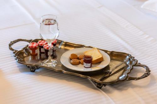 a tray with a plate of food and a glass of wine at Villy's Comfort Zone Apartments in Kalamata