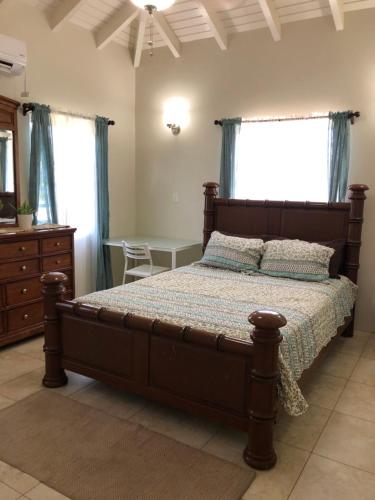 a bedroom with a bed and a table and windows at Falmouth Sea View Loft in Falmouth
