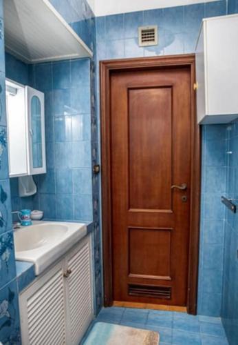 a bathroom with a wooden door and a sink at 5 min dalla Spiaggia Terrazza Vista Mare in Zoagli