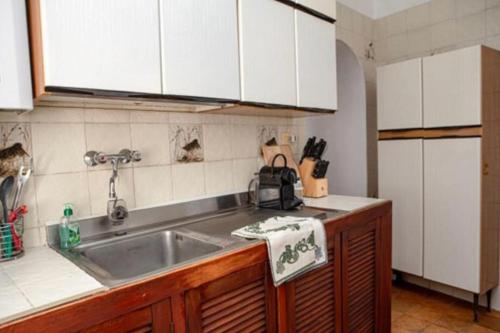 a kitchen with a sink and white cabinets at 5 min dalla Spiaggia Terrazza Vista Mare in Zoagli