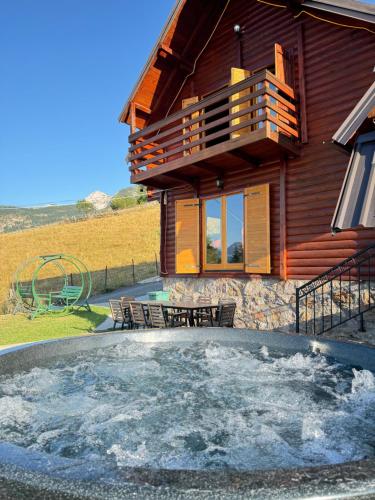 a log house with a hot tub in front of it at Villa Route Rugove in Peje