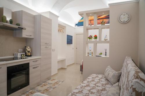 卡塔尼亚I tre fanciulli的厨房配有沙发和墙上的时钟