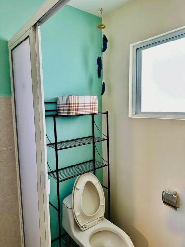 a bathroom with a white toilet in a room at Departamento La mejor vista de Acapulco en CasaBlanca Grand in Acapulco