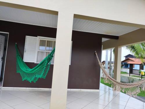 a hammock hanging on the side of a house at Casa na praia, 100 metros do mar in Arroio do Silva