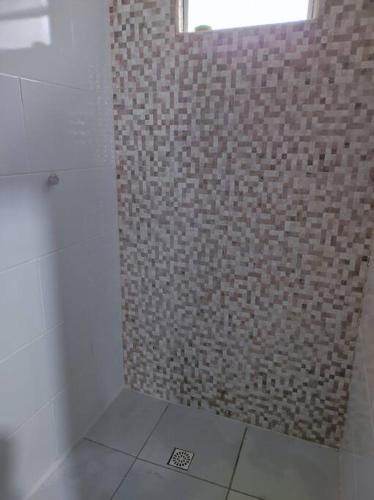 a bathroom with a shower with a brick wall at Casa na praia, 100 metros do mar in Arroio do Silva