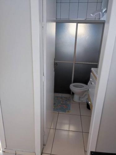 a small bathroom with a toilet and a tile floor at Casa na praia, 100 metros do mar in Arroio do Silva