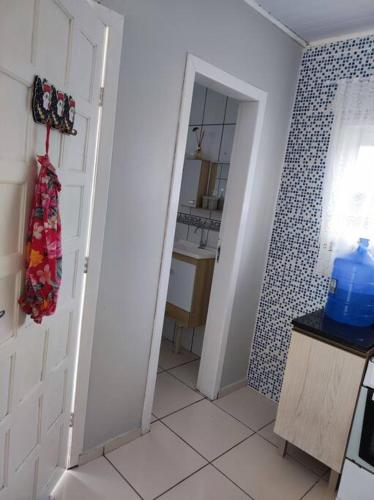 a bathroom with a white door and a sink at Casa na praia, 100 metros do mar in Arroio do Silva