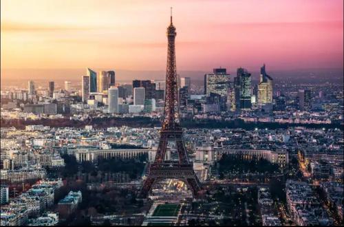 une vue aérienne sur la tour eiffel au coucher du soleil dans l'établissement Appartement 85m2 La Défense,Balcony, à Courbevoie
