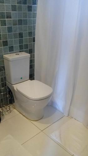 a bathroom with a toilet with a shower curtain at Le Vie in Becke Moui