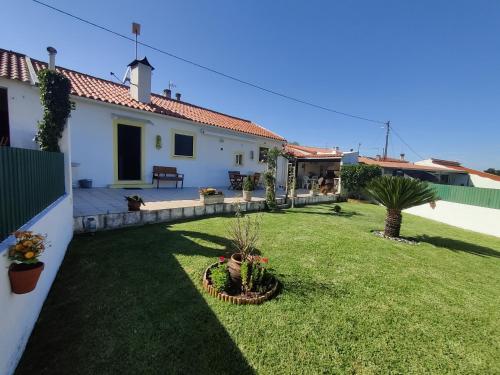 a backyard of a white house with a green yard at A casinha in Cerejeiras