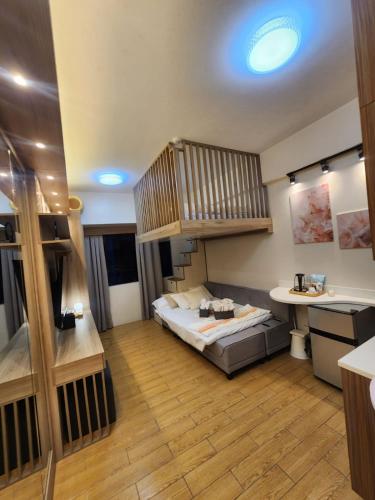 a large room with a bed and a staircase at Nordic Rsquare Manila - with Pool Access in Manila