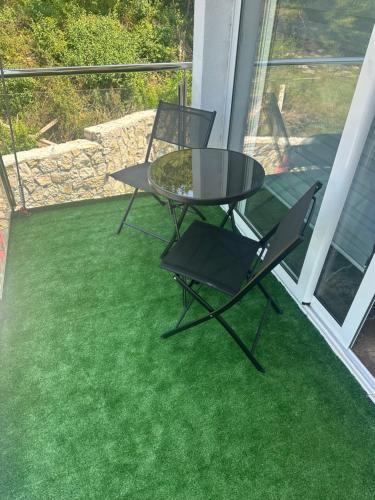 a patio with a table and two chairs on the grass at Brioni in Virpazar
