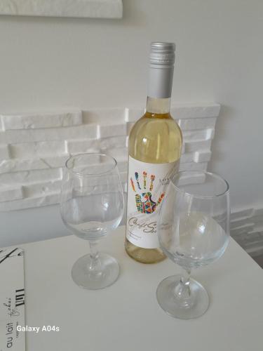a bottle of wine and two glasses on a table at Studio Apartment with Pool View, Sunny Beach in Sunny Beach