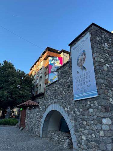 un edificio in pietra con un cartello sopra di Mother Teresa Apartment a Skopje
