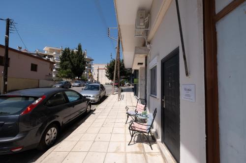 a child sitting in a chair on a sidewalk at Athanias Studio in Drama