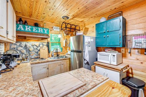 a kitchen with a stainless steel refrigerator and wooden walls at Patio and Fire Pit Charming Cabin in Roaring Gap! in Abshers