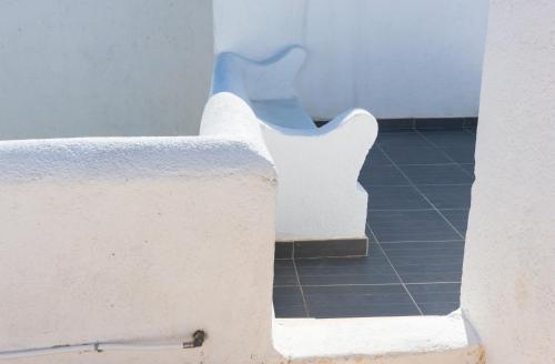 two white benches in a room with a tile floor at Elounda Island Villas in Elounda