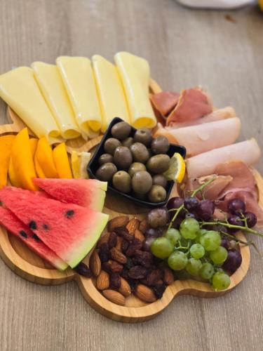 a plate of food with different types of cheese and fruit at Hotel Gorica - UNESCO quarter in Berat