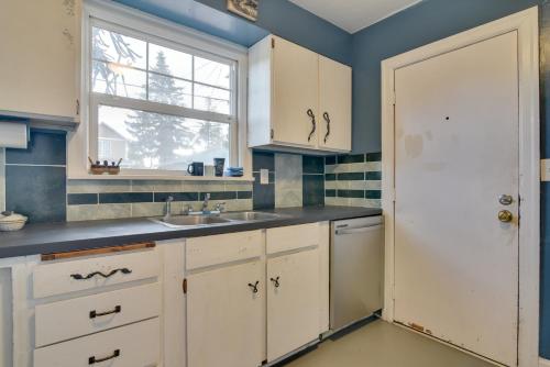 Una cocina con gabinetes blancos y un fregadero y una ventana. en Charming Historic Portland Home Near Downtown, en Portland