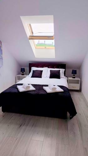 a bedroom with a large bed and a skylight at Apartamenty Chęciny in Chęciny