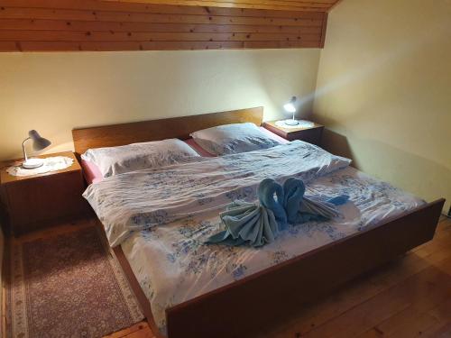 a bed in a bedroom with two lamps on tables at Farm stay Majdač in Solčava