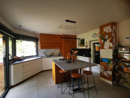 une cuisine avec un îlot et des tabourets. dans l'établissement Maison familiale avec jardin, à Montpellier