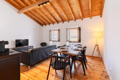 a dining room with a table and chairs and a couch at Casas Miguel Bombarda in Castelo de Vide