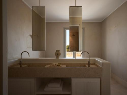 a bathroom with a large sink and a mirror at Akria Seaside Suites in Naousa