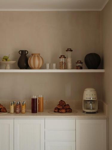 a kitchen counter with a toaster and a plate of food at Akria Seaside Suites in Naousa