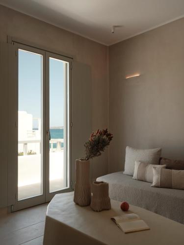 a bedroom with two beds and a view of the ocean at Akria Seaside Suites in Naousa