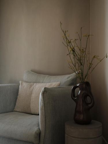 a vase sitting on a table next to a couch at Akria Seaside Suites in Naousa