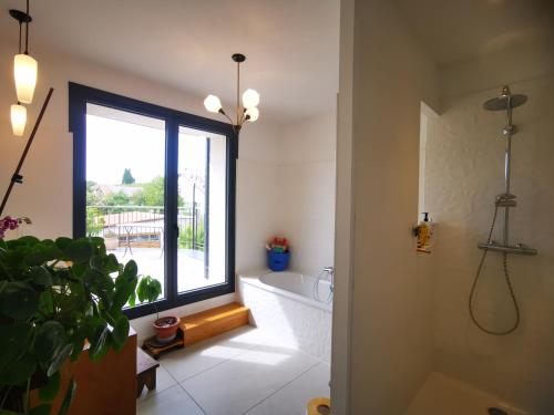 La salle de bains est pourvue d'une fenêtre, d'une baignoire et de toilettes. dans l'établissement Maison familiale avec jardin, à Montpellier