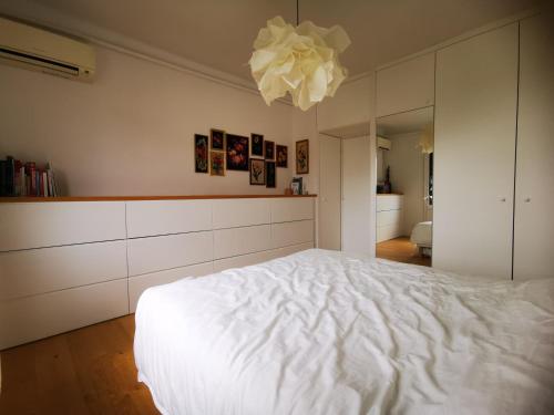 - une chambre avec un lit blanc et un lustre dans l'établissement Maison familiale avec jardin, à Montpellier