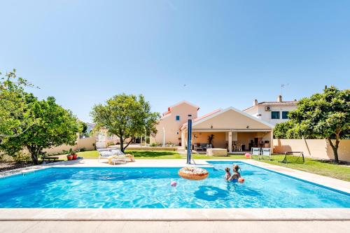 a couple playing in a swimming pool at Villa Laranja-Limao in Azeitao