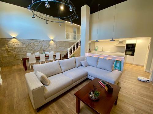 ein Wohnzimmer mit einer weißen Couch und einem Tisch in der Unterkunft Villa Maca in Pontevedra