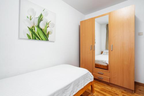 a bedroom with a bed and a cabinet with a mirror at Blue Horison Apartments by In Property in Pržno