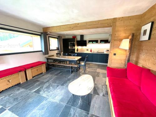 un salon avec un canapé rouge et une table dans l'établissement Appartement de charme avec grande terrasse et vue dégagée - FR-1-505-35, à Notre-Dame-de-Bellecombe