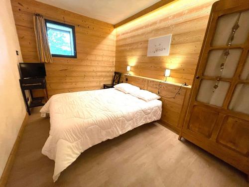 une chambre avec un lit dans une pièce en bois dans l'établissement Appartement de charme avec grande terrasse et vue dégagée - FR-1-505-35, à Notre-Dame-de-Bellecombe