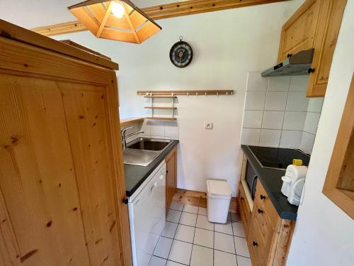 une petite cuisine avec un évier et un comptoir dans l'établissement Appartement ski aux pieds, 2 chambres, terrasse et parking couvert - La Clusaz - FR-1-459-49, à La Clusaz