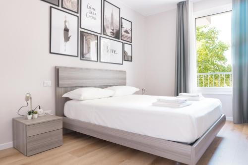 a white bedroom with a large bed and a window at Casa Eolo Mare e Relax in Lido di Jesolo