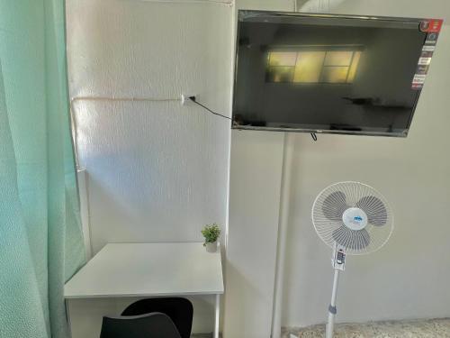 グアテマラシティにあるUrban Hotelのファンと窓が備わる白い客室です。