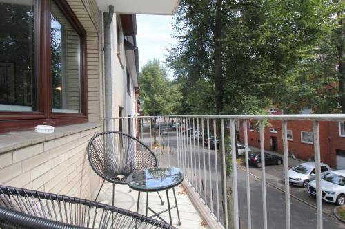 a glass table and a chair on a balcony at City Apartment Bremen an der Weser in Bremen