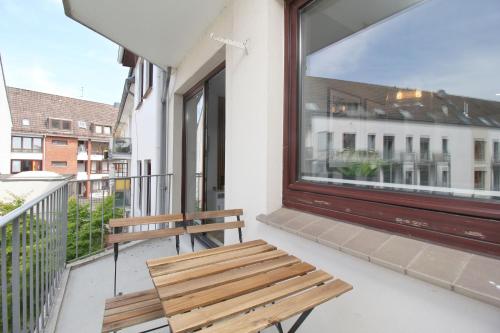 a wooden bench sitting on a balcony with a window at City Apartment Bremen an der Weser in Bremen