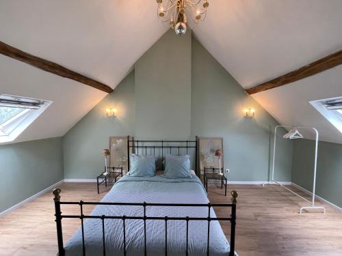 a bedroom with a bed in a attic with skylights at Gite de Fleur - Chateau du Grand Luçay in Bourbon-lʼArchambault