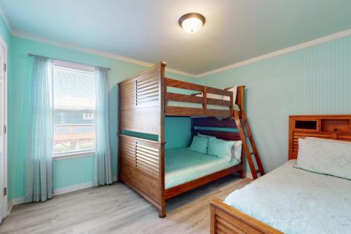 a bedroom with two bunk beds and a window at Pelican Perch in Dauphin Island
