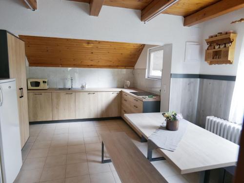 Una cocina con gabinetes de madera y una mesa en ella. en Chata Martina, en Bešeňová