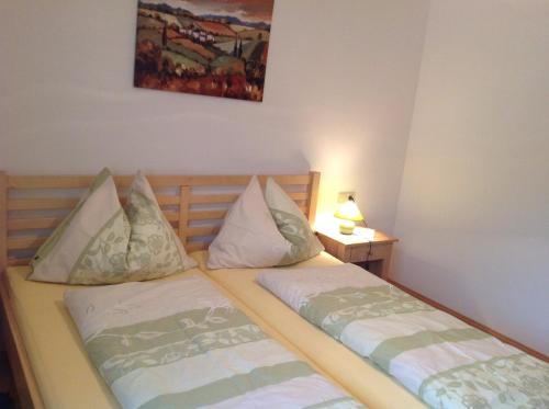 2 Einzelbetten in einem Zimmer mit einer Lampe in der Unterkunft Beerenthal in Karnberg