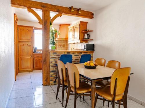 une salle à manger avec une table et des chaises dans une cuisine dans l'établissement La Rosée - 2 pièces familial, jardin privatif, à Bourbonne-les-Bains